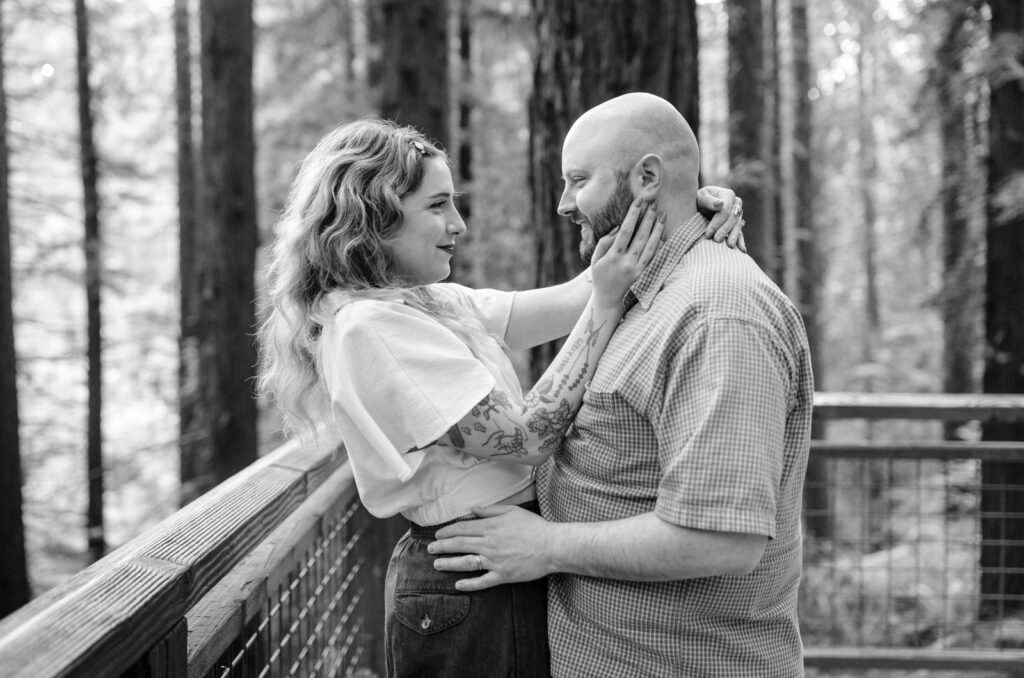 PNW engagement photo of a couple looking at each other in the woods, photo by Jenny Kang Photography